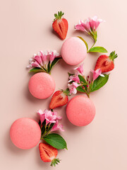 flat lay composition with macaroons, strawberries, flowers on beige background. Traditional french dessert. vertical image