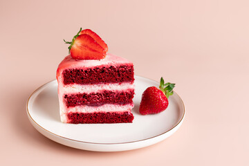 piece of delicious red velvet cake decorated with fresh strawberries. sweet holiday treat. pink background. copy space