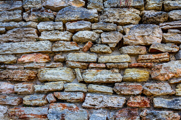 An old wall of stone. Old masonry. The stone is in the wall. stone fence.