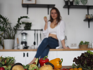  young woman nutritionist prepares a delicious and healthy breakfast. Cuts salad, vitamins, vegetables and fruits