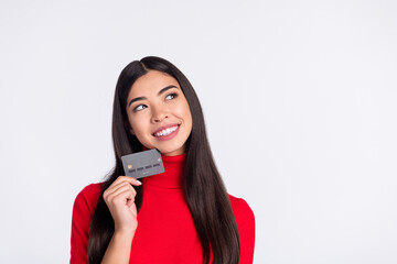 Photo of happy smiling cheerful woman look copyspace dreaming hold credit card isolated on grey...