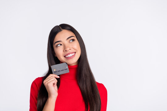 Photo of happy smiling cheerful woman look copyspace dreaming hold credit card isolated on grey color background