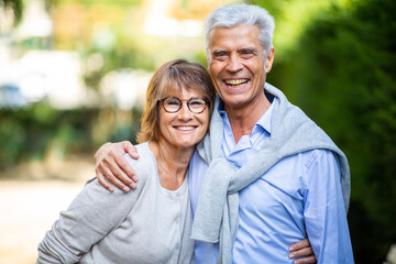 happy mature couple in each other arms outside in park