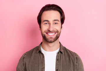 Photo of excited funny young man wear brown shirt smiling isolated pink color background