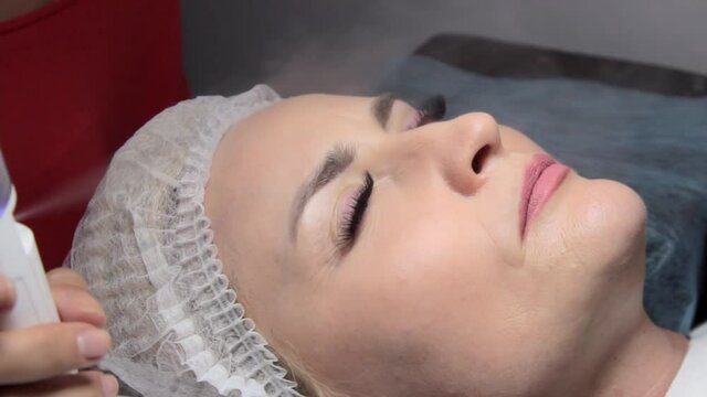 in the beauty salon, after applying the eyelashes, the master irrigates the eyelashes with a nebulizer to accelerate the polymerization of the glue
