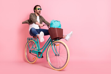 Photo of sweet cute guy dressed brown shirt dark eyeglasses riding bike backpack looking empty...