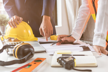 Builder young engineer man and architect woman are discussing construction from a plan to follow...