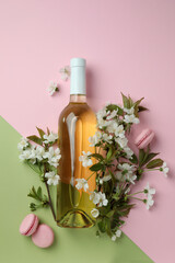 Wine, macaroons and flowers on two tone background