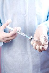 Nurse or doctor holds syringe and vaccine bottle in hands. Close-up. Coronavirus and influenza vaccination.