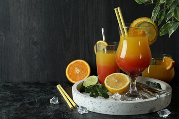 Tequila sunrise cocktails and ingredients on dark background