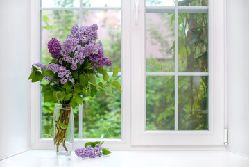 Bouquet of lilac in a vase on the windowsill