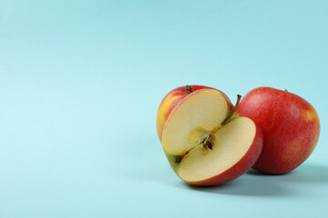 Ripe apples on blue background, space for text