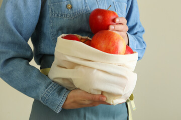 Woman holds bag with ripe red apples