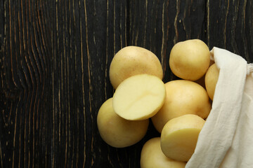 Bag of young potato on wooden table