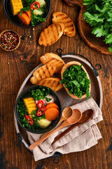Chilean meat soup with pampkin, corn, fresh coriander and potatoes on old wooden table background. Cazuela. Latinamerican food.