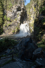 The fabulous alpine waterfalls of Riva in the Dolomites (Campo Tures). Path of San Francesco with Tobl Castle ruins. Lovely place in the Alps. Sunny spring day with no people. Trentino Alto Adige.