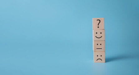 Smile face symbol on yellow wooden cube blocks on blue background and copy space. For improvement...
