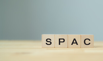 SPAC symbol. Wooden cubes with words SPAC, special purpose acquisition companies' on beautiful grey...