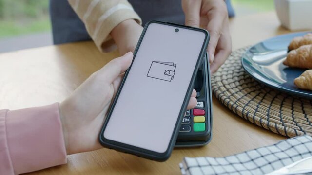 Asia young smile happy woman people in small sme coffee shop store use tapping cashless wifi qr code nfc scan app smart pos device reader sale in food drink order in caf&eacute; urban city life contactless.