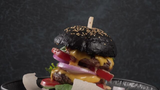 Big black burger with double beef cutlet, melted cheese and spinach rotate
