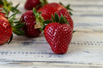 Strawberry in basket and on table on wooden background
