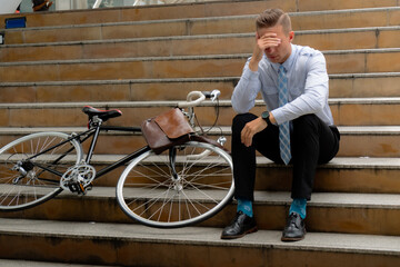 Unemployed man sitting on the outside stair feel stressful depressed situation in Covid 19 crisis business, Dismissal from work. Job loss. Reduction of the company's staff. Jobless concept.