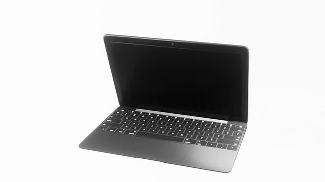 3D Rendered laptop floating above a bright white background. The laptop spins as it opens, slowly revealing the keyboard and blank screen.