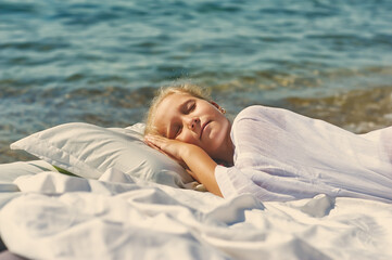 Sleeping little girl outdoors, child daytime sleep at seaside resort