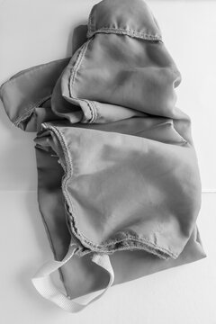 Folded Nylon Laundry Bag With Cloth Handle In Black And White - Photographed From Above