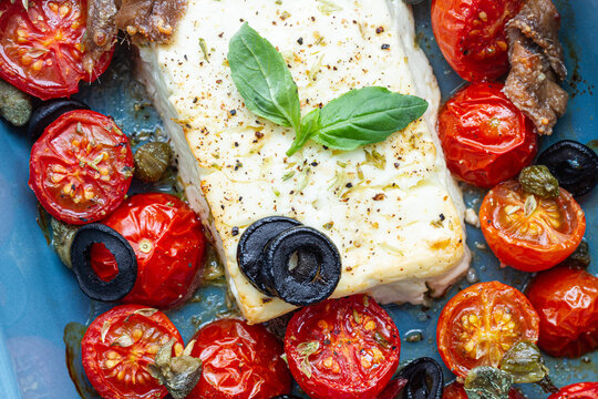 Baked cherry tomato halves with feta cheese in baking pan