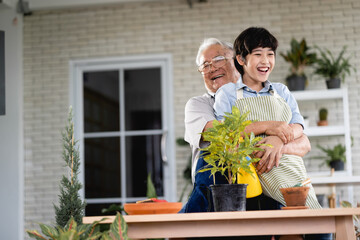 Grandfather gardening and teaching grandson take care  plant indoors