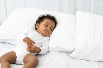 black african american baby sleeping on a white mattress.