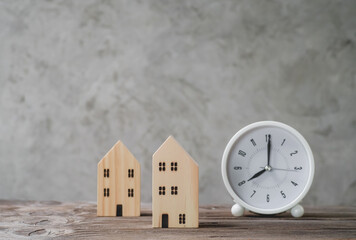  mini wood house model with clock on wood table, Planning to buy property. concept of choose the...