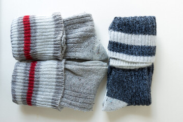old wool socks folded and isolated on an old white paper background