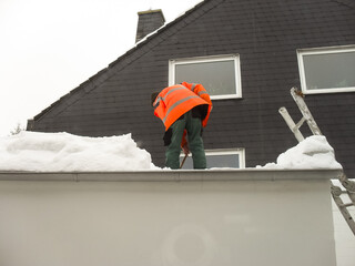 Man removing snow from roof