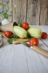 zucchini, tomatoes and parsley on a white wooden background