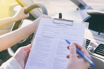 Examiner filling in driver's license road test form