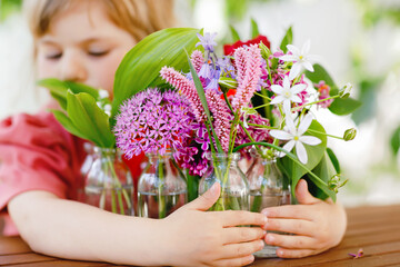 Close up of little preschool girl with flower bouquet at home. Close-up of toddler child and...