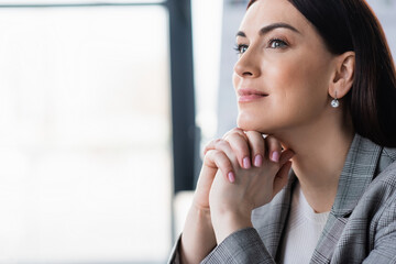 Smiling businesswoman in formal wear looking away in office