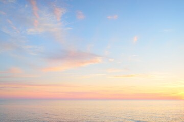 Baltic sea at sunset. Dramatic sky, blue and pink glowing clouds, soft golden sunlight, midnight sun. Picturesque dreamlike seascape, cloudscape, nature. Panoramic view