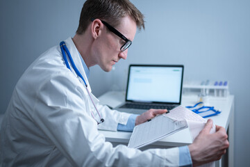 Cardiologist reading an ECG print-out. Doctor analyzing electrocardiogram. Practitioner examine patient test results. Medical and healthcare concept. Physician looking at cardiogram at medical office