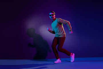 Full body photo of funky happy young positive man good mood dance isolated on neon light background