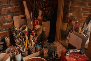 Image of cozy home workshop of interior clay studio with pottery tools on wooden table