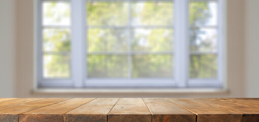Wooden desk of free space and window background 
