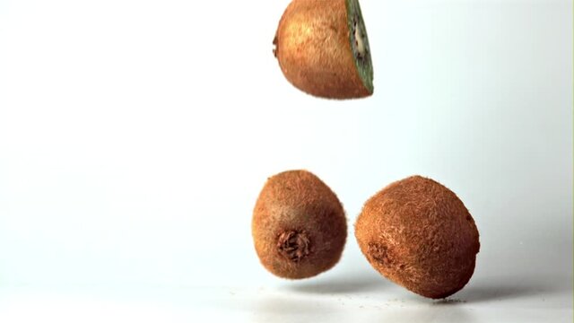 Super slow motion kiwi halves fall on the table. On a white background. Filmed on a high-speed camera at 1000 fps.High quality FullHD footage