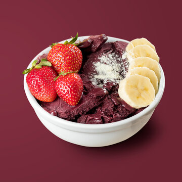 Brazilian Frozen Açai Berry with Strawberries, Bananas and powdered milk on a white round pot. Isolated on Purple background.