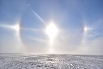 sun dogs over frozen field