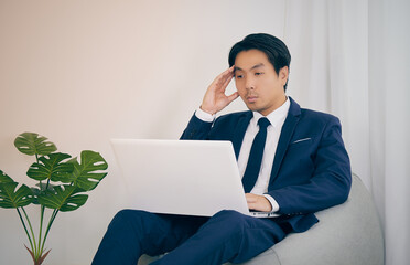 Asian Financial Advisor Headache and Using Laptop Computer in Home Office. Businessman Work at Home for Social Distance or Home Quarantine in Covid 19 or Coronavirus Situation in Vintage Tone