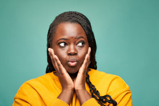 Content black woman holding face in hands in studio