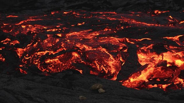 Primordial scenic landscape with fiery red lava river. Panning
